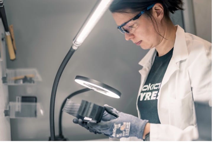 Woman looks at tire in lab